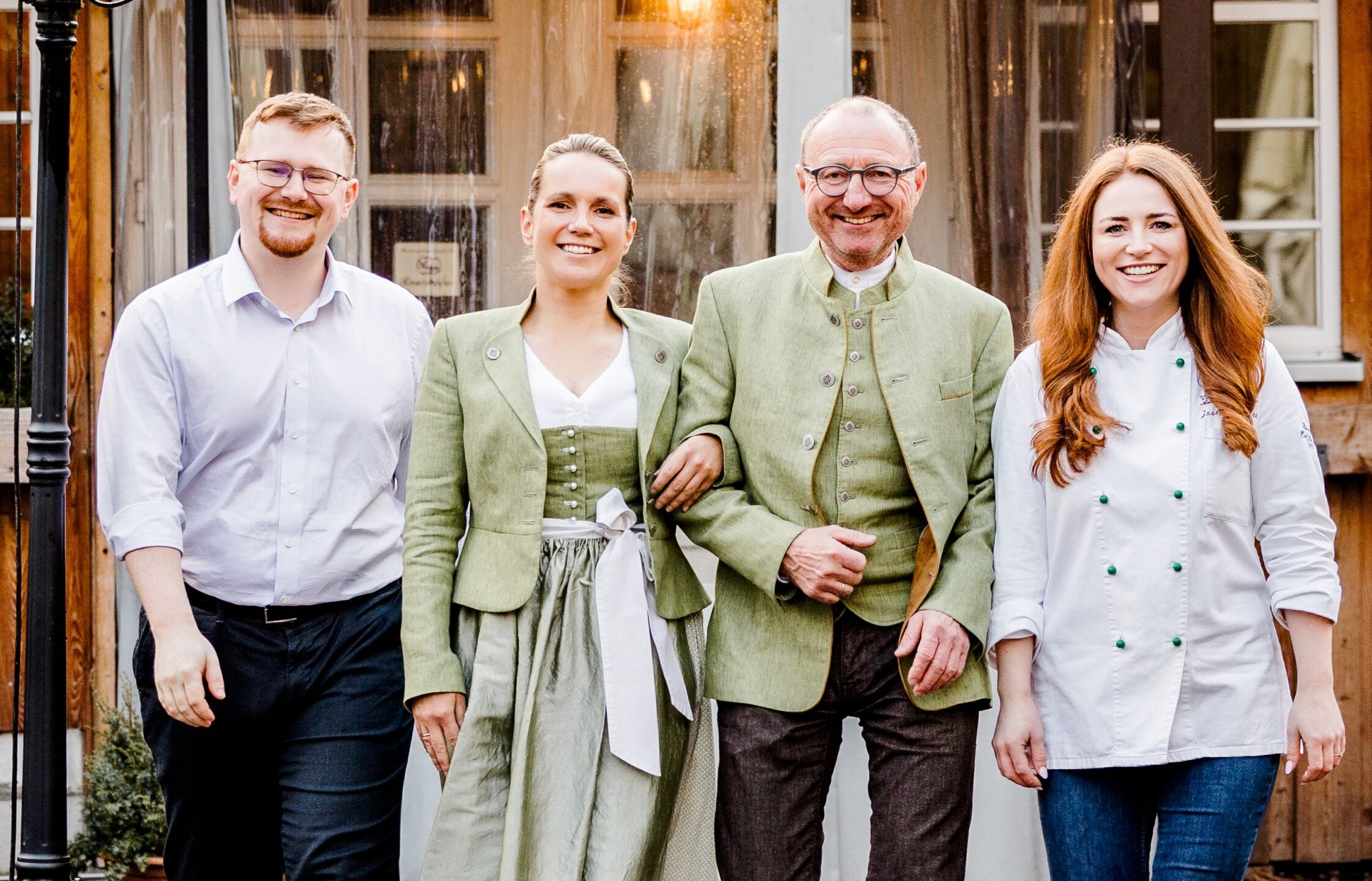 Vierköpfiges Team der Fleischerei Schulze vor dem Gebäude in Dresden; zwei Personen in grüner Tracht, eine Köchin in weißer Jacke und ein Mitarbeiter im Hemd.